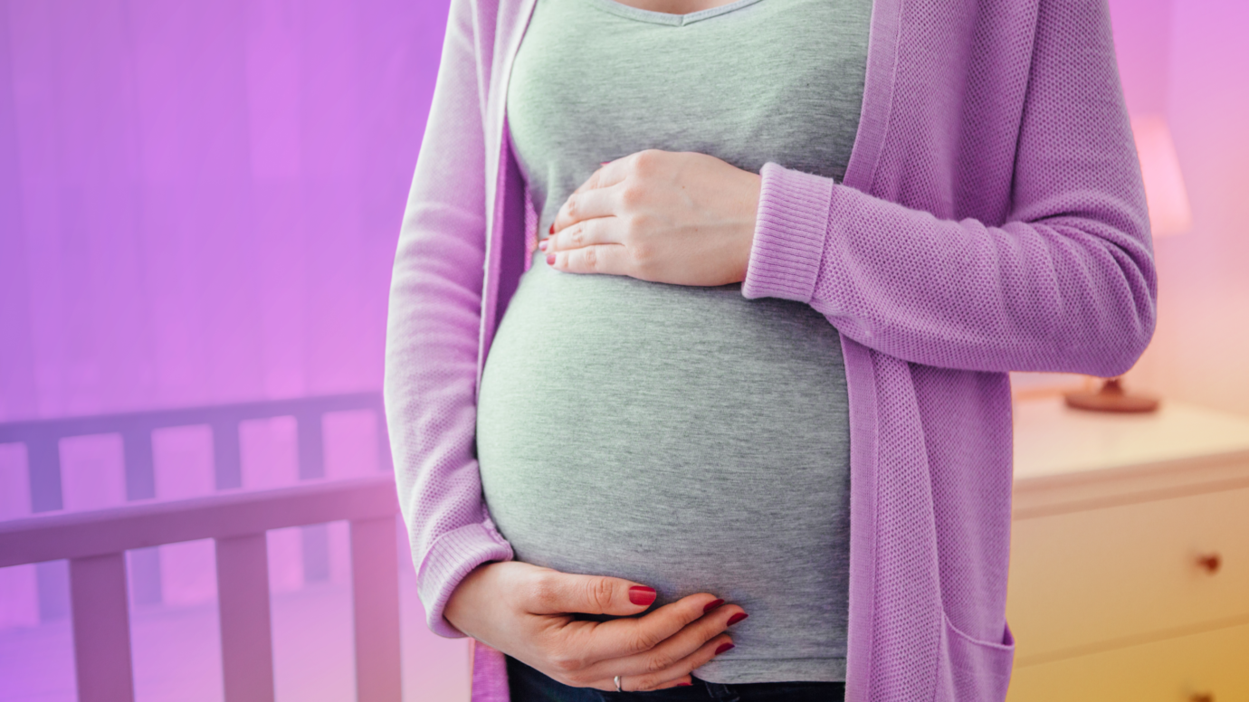 women holding her belly inside of nursery