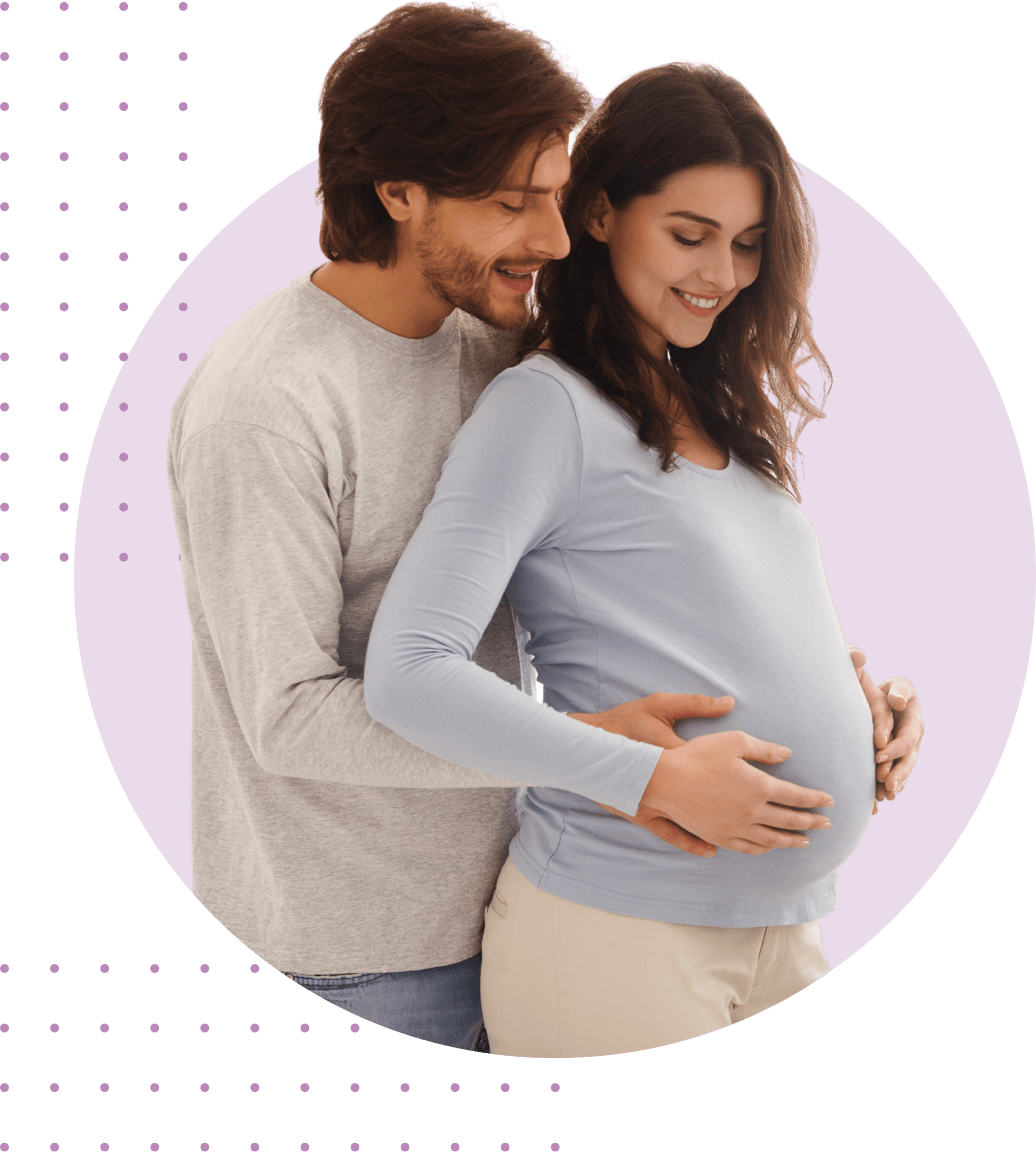 white male holds pregnant women's belly up from behind